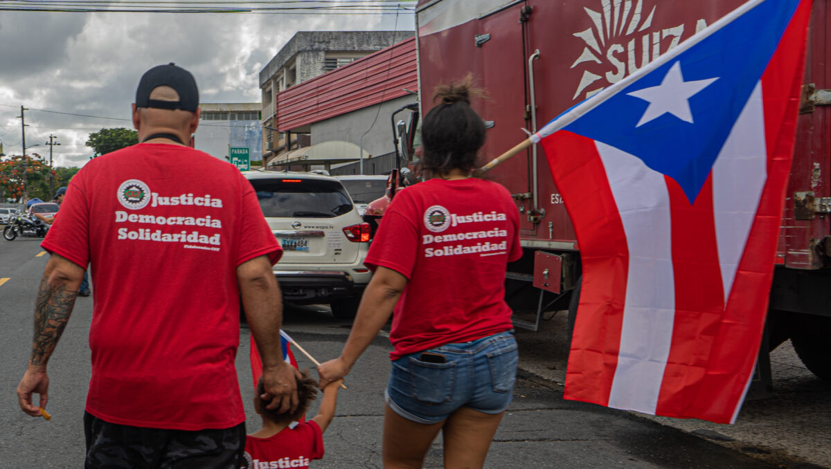 Familia de trabajadores de la Suiza Dairy portando una bandera de Puerto Rico